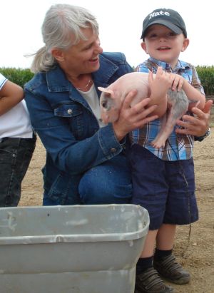 The farmer's wife is showing a day old pig to Nate in Freeman, South Dakota.